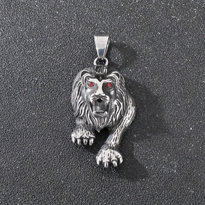 Detail shot of a punk lion head pendant with red gemstone eyes on black background