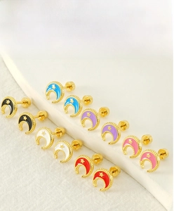 Detailed view of colorful enamel star and moon stud earrings with screw back design
