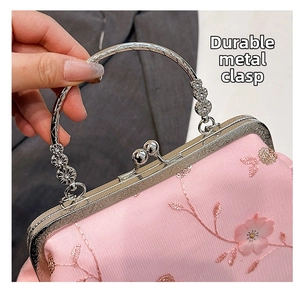 Close-up of pink embroidered fabric bag with metallic handle and retro clasp
