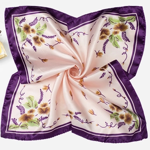 Detail of elegant pink and purple square silk scarf with floral patterns in swirl fold