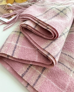 Gros plan sur l'écharpe à carreaux rose en cachemire synthétique avec détails de franges