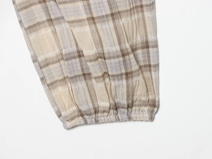 Macro shot of plaid seersucker fabric detailing and elastic cuff stitching on the top