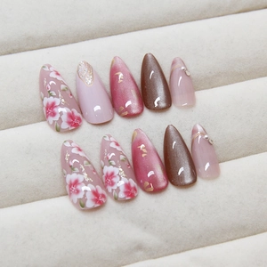 Cat eye press-on nails with pink peach blossom designs and pearl accents