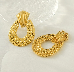 Vue détaillée de boucles d'oreilles coquillage dorées mates avec texture en losange