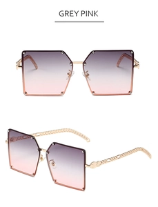 Detail of square oversized grey-pink gradient sunglasses with gold chain temples
