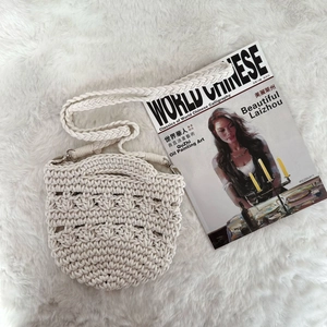 Close-up of beige crochet cotton shoulder bag with woven texture on plush rug