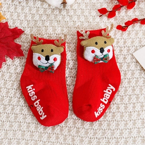Macro detail of red baby Christmas socks with 3D reindeer decor and anti-slip soles