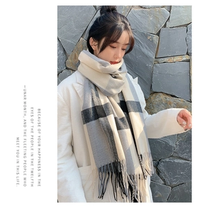 Detail of plaid cashmere-like scarf with long tassels and winter checkered pattern