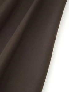 Macro detail of dark brown textile fabric with fine weave and natural pleated texture