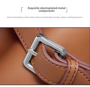 Detailed macro view of silver metal buckle and stitching on brown leather handbag