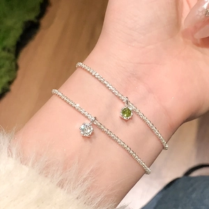 Élégant bracelet en perles argentées avec pierres vertes et blanches au poignet