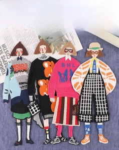 Detail shot of four cartoon girl embroidery patches with intricate fabric textures
