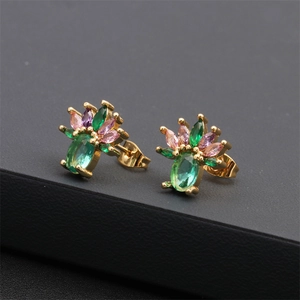 Macro view of gold-plated floral earrings with green oval and colorful marquise stones