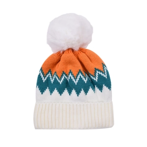 Detail of colorful knit hat with zigzag patterns and a large fluffy pom-pom top