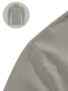 Close-up of breathable linen fabric texture and pocket detail on a grey long sleeve shirt