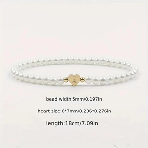 Detail of beaded pearl bracelet with heart-shaped golden letter A charm pendant