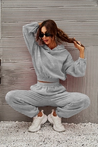Detail of grey hooded tracksuit featuring ribbed cuffs and soft fleece fabric texture