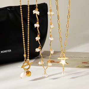 Elegant gold pearl necklace set with star pendant and OT buckle on leather background