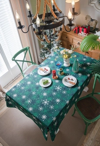 Détail de la nappe de Noël verte présentant d'élégants motifs de flocons de neige blancs
