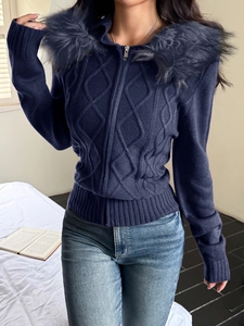 Detail of dark blue knit sweater with a fuzzy faux fur hood and diamond pattern