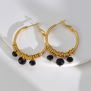 Detailed shot of 14k gold U-shaped hoop earrings featuring faceted black beads for women