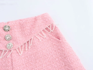 Detail der rosa Tweed-Shorts mit Kristallknöpfen und Perlenfransen-Quasten an der Taille
