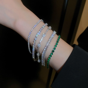 Détail de 5 bracelets de tennis superposés en argent et émeraude avec des zircons