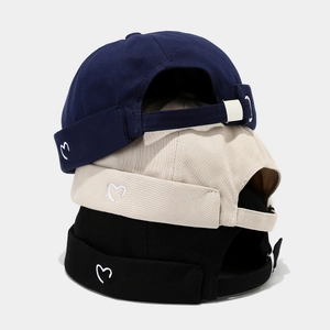 Three cotton miki hats in navy, beige, and black with small heart embroidery details
