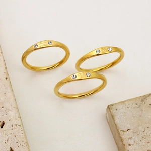 Detailed view of three 18K gold-plated zodiac rings featuring Aquarius, Pisces, and Aries symbols