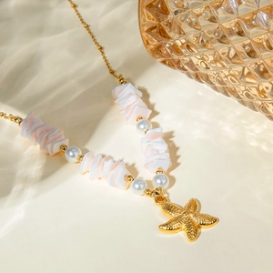 Detailed shot of 18k gold starfish necklace with mint shell pieces and round pearls