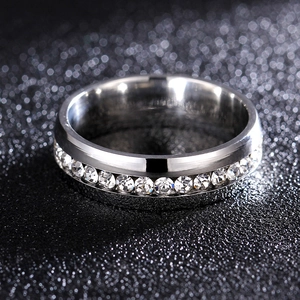 Macro shot of a 6mm silver titanium steel ring with sparkling round zircons on black background