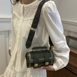 Green Boston bag with vintage studs and bohemian wide strap worn by a female model