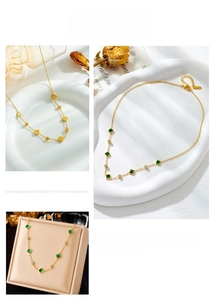 Detail view of a gold-plated stainless steel chain with square emerald stones and diamonds