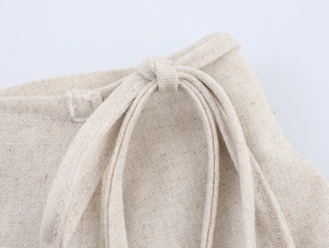Dettaglio della trama di lino beige con coulisse in vita di un completo casual raffinato