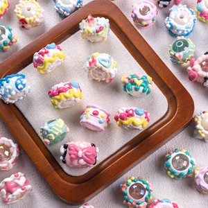 DIY colorful resin dessert beads in cake and donut shapes on a wooden tray with linen
