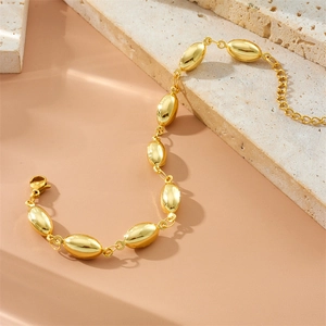 Detail view of gold-plated bean links bracelet with adjustable lobster clasp on stone