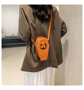 Rear view of model wearing the orange pumpkin crossbody bag with a ghost face design