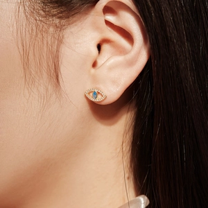 Gros plan détaillé d'un clou d'oreille mauvais œil en argent S925 doré avec zircon bleu