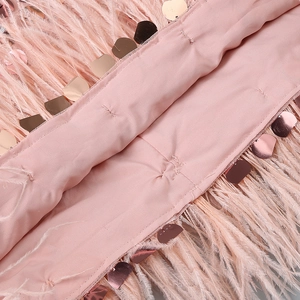 Détail macro des paillettes roses et plumes douces sur une robe de soirée sexy