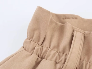 Dettaglio degli shorts a palloncino in cotone kaki con vita elastica a pieghe e passanti