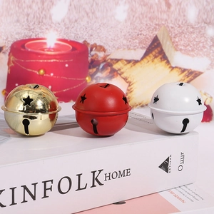 Détail de cloches de Noël de 5 cm rouges, dorées et blanches avec découpes en étoile
