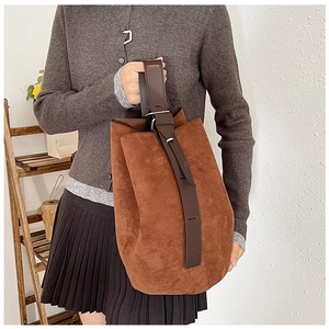 Brown suede tote bag shown on model's arm for daily commute style demonstration