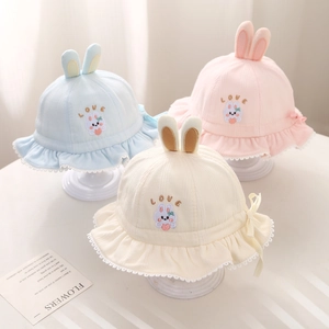 Close-up of knit cotton baby bucket hats with bunny ears, embroidery and lace edges