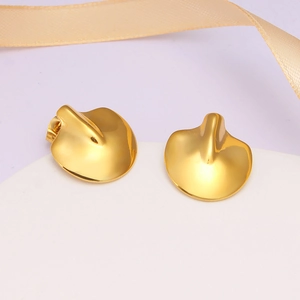 Detail of irregular petal-shaped gold earrings with light orange silk ribbon decor