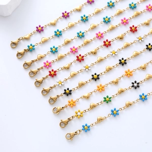 Detailed view of multiple 18k gold plated stainless steel bracelets with daisy charms