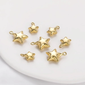 Detailed view of seven polished 14K gold star charms in various sizes for DIY jewelry