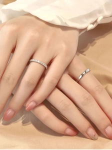 Close-up of silver pave-set diamond ring and classic screw pattern band on a model