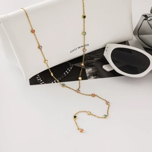 Collier chic en Y doré en acier inoxydable avec strass colorés sur un sac blanc