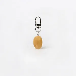 Close-up of handmade realistic potato keychain charm with textured brown finish