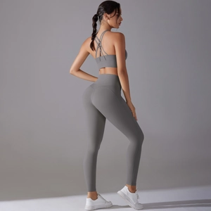 Detail of cross-back sports bra and high-waist yoga leggings in dark grey finish
